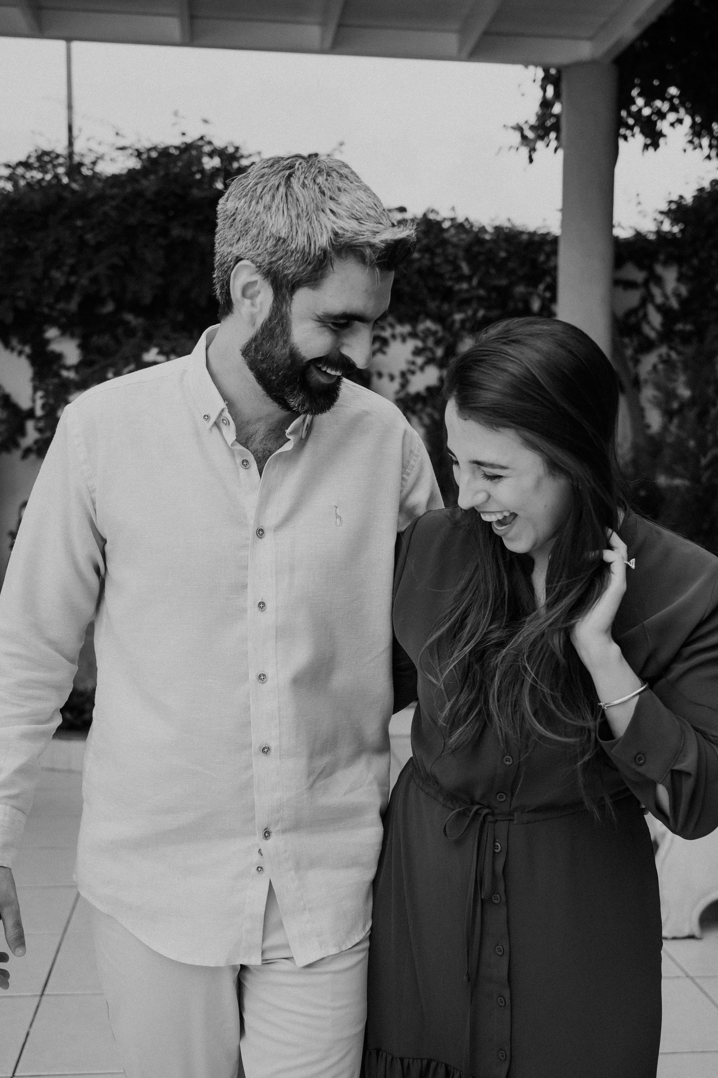 María Paula y Matías en blanco y negro, caminando y riendo juntos en un jardín